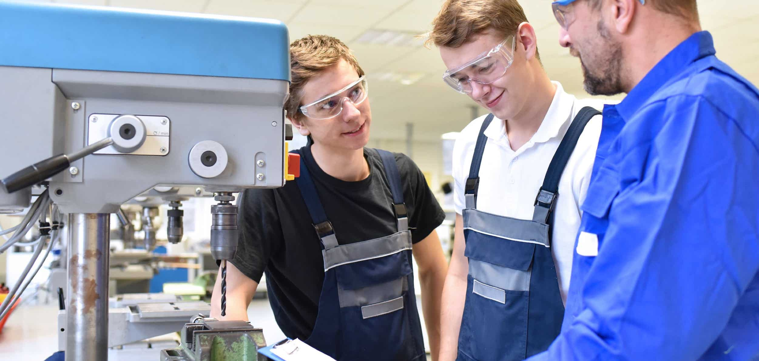 Schüler mit Meister an einer Maschine